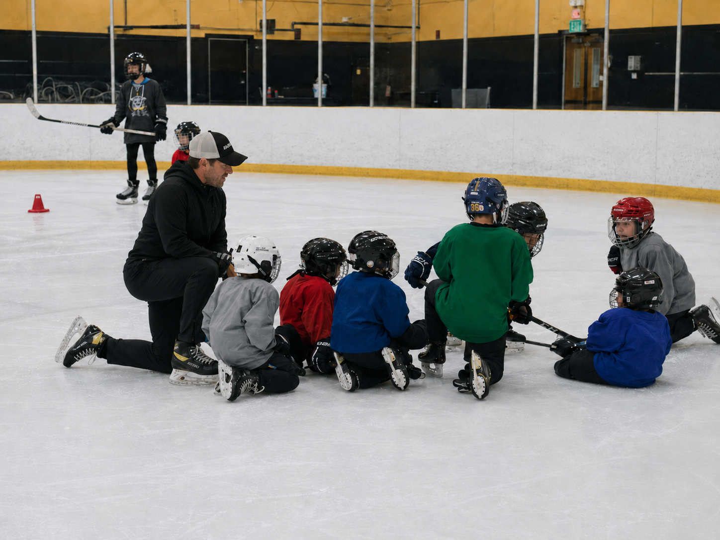 Coach guiding young hockey players during an on-ice training session.